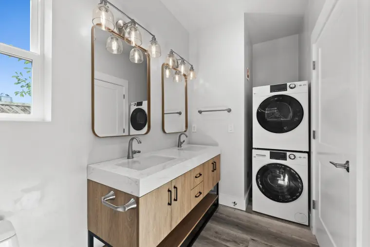 End of the double vanity with a stacked washer and dryer alongside