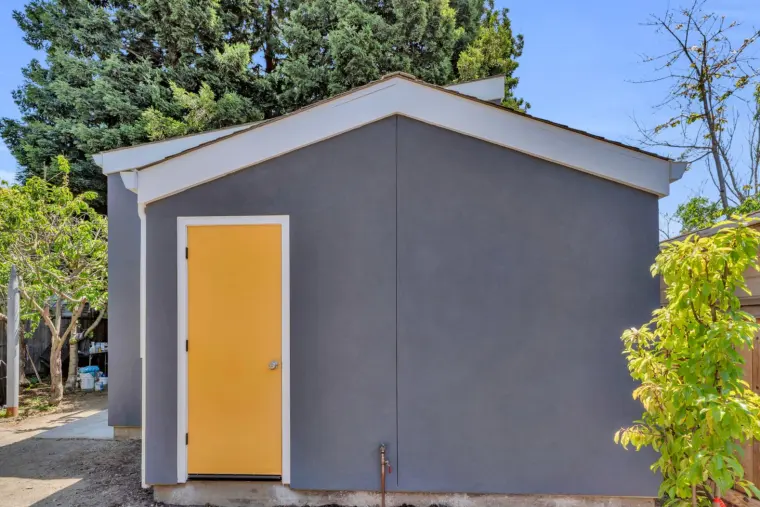 The ADU's yellow front door set in gray stucco