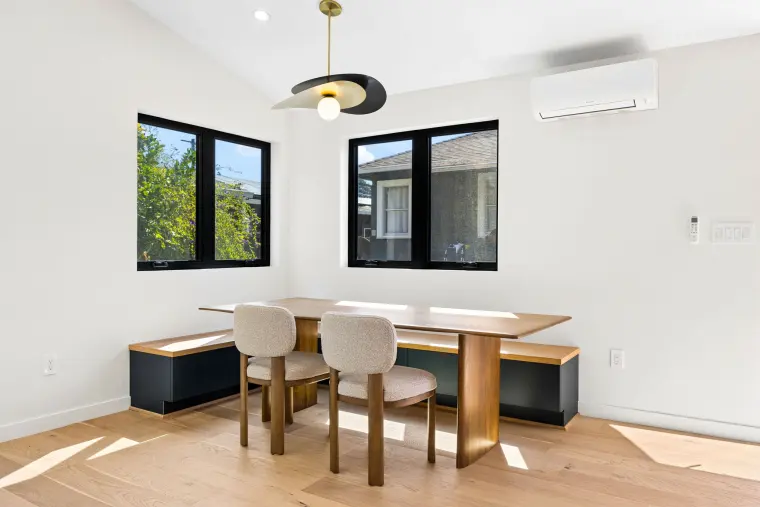 Dining nook with a built-in bench, oak table, and a sculpted pendant light