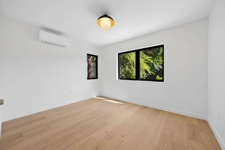 Bedroom with two black windows and a globe ceiling light