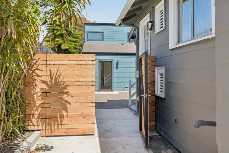 Side yard path with a wood gate leading back to the ADU