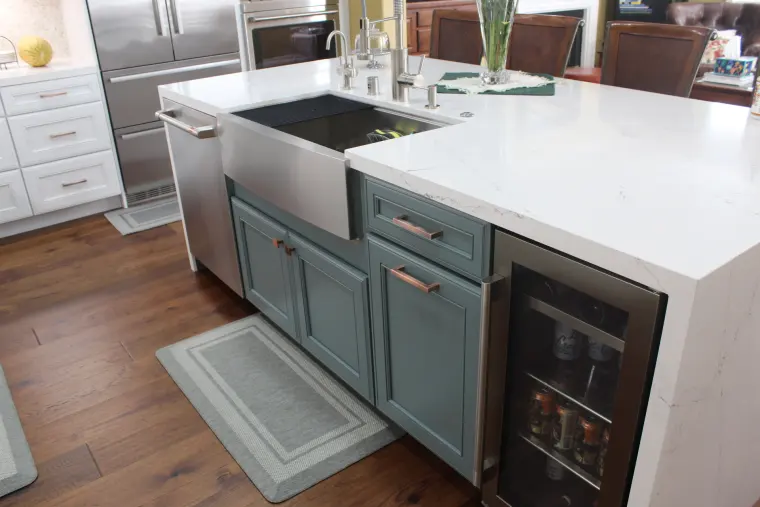 Blue-gray island cabinets with a stainless farmhouse sink and a wine fridge