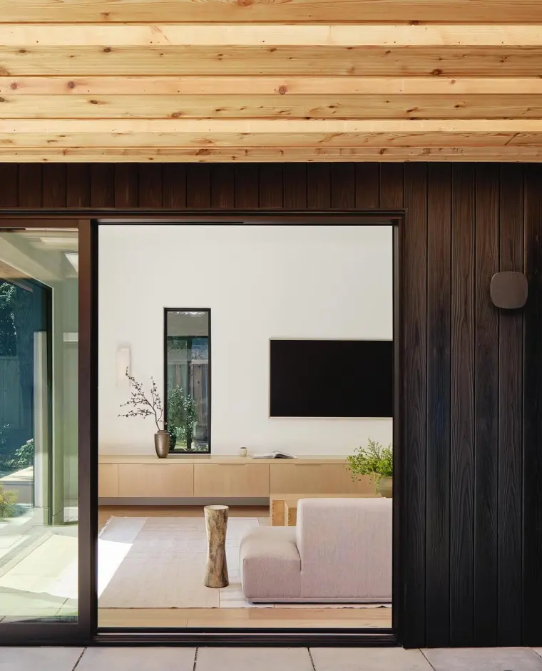 Looking through the charred-cedar doorway into the bright living room