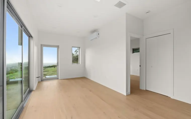 Finished empty bedroom with sliding glass door, closet, mini-split AC unit, and expansive hillside view
