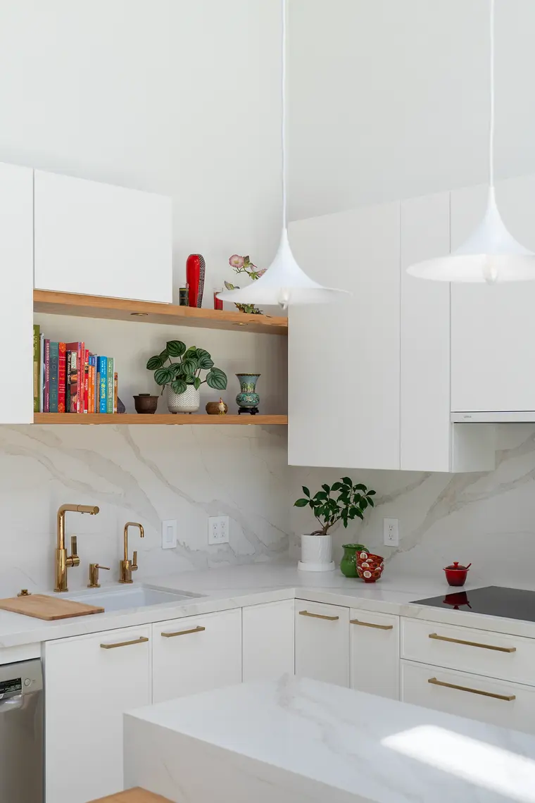 Kitchen corner with a brass faucet and filtered tap, a veined slab backsplash, open oak shelves, and an induction cooktop