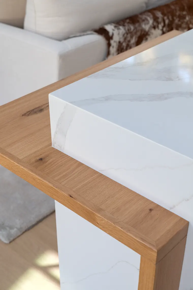 Close detail of the white oak ledge meeting the island’s waterfall slab
