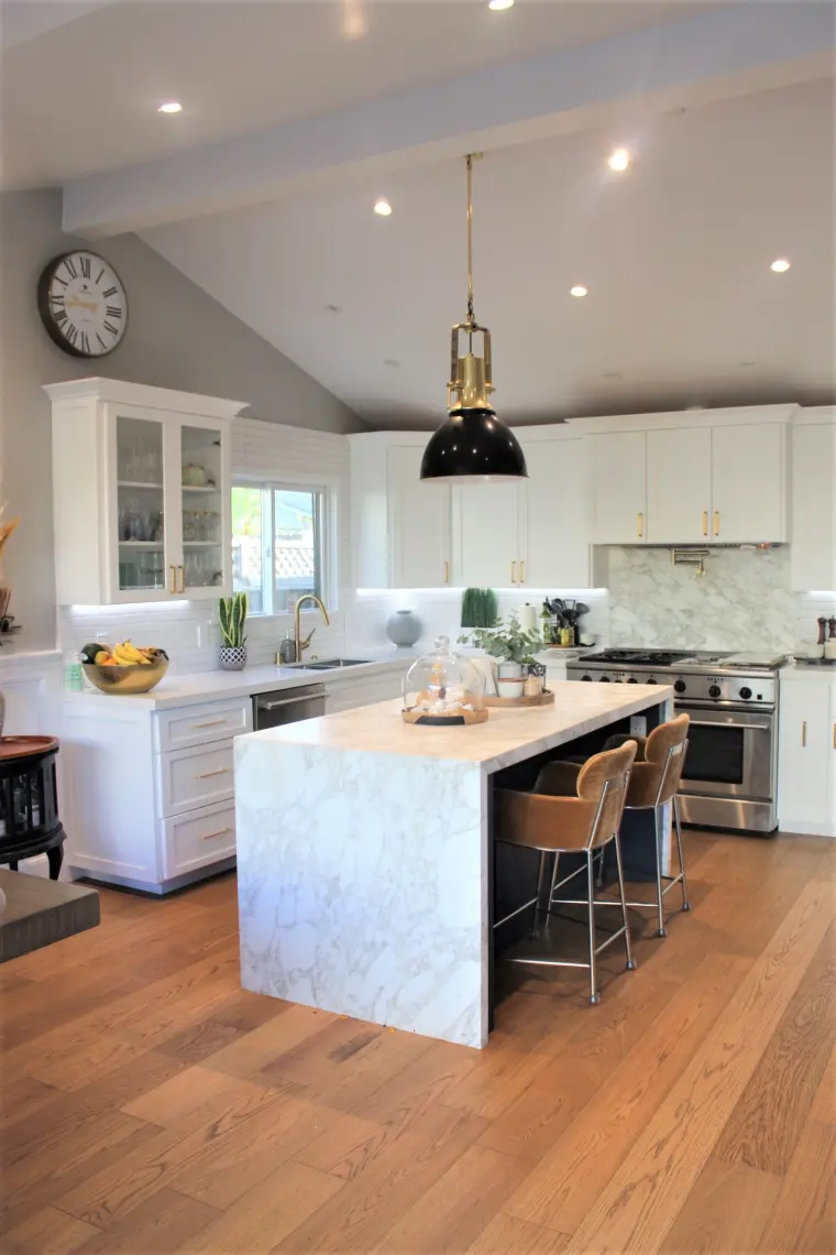 Full kitchen view with the waterfall island and marble slab behind the range