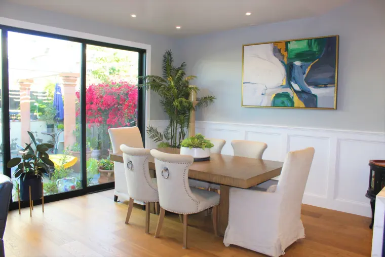 Dining room with wainscoting and a black sliding door to the backyard