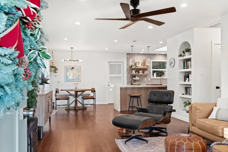 Living room with a leather lounge chair and a view through to the dining area and kitchen