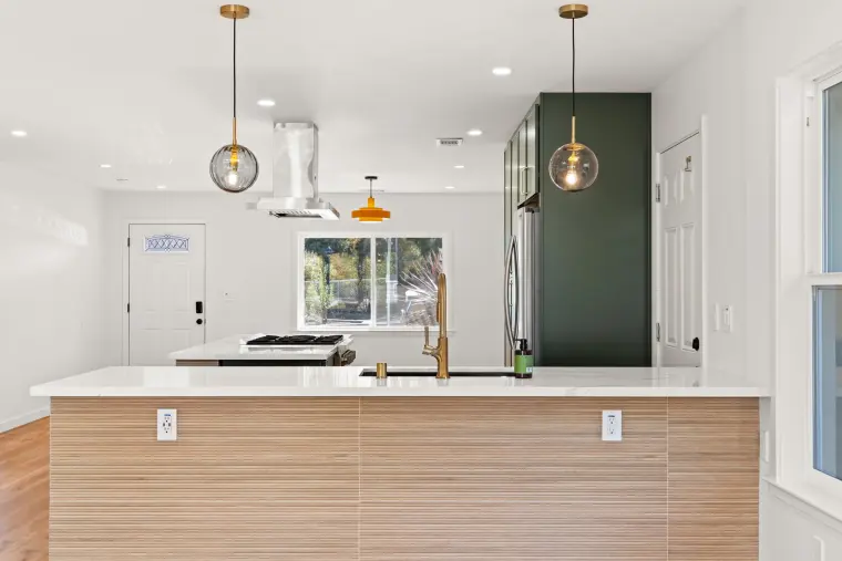 Wood-look peninsula front with white quartz on top and brass pendants above