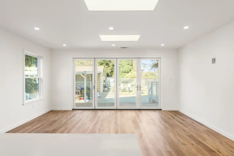 New back room with a skylight and glass doors to the deck