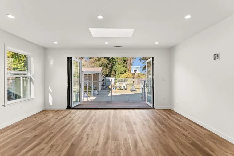 Addition with folding glass doors opened all the way to the deck and backyard
