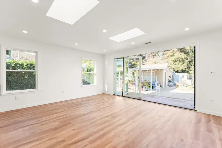 Addition with skylights and a wide glass door opening to the backyard