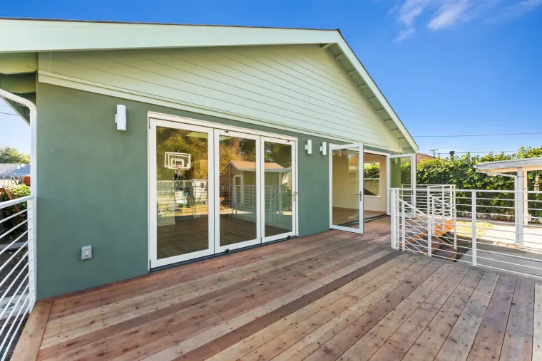 New wood deck with white railings along the back of the addition