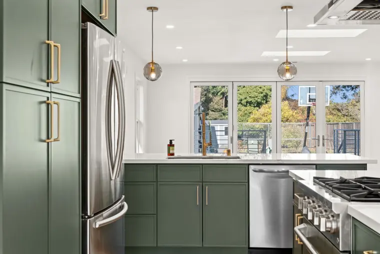 Sink wall under a row of windows with glass doors to the backyard beyond